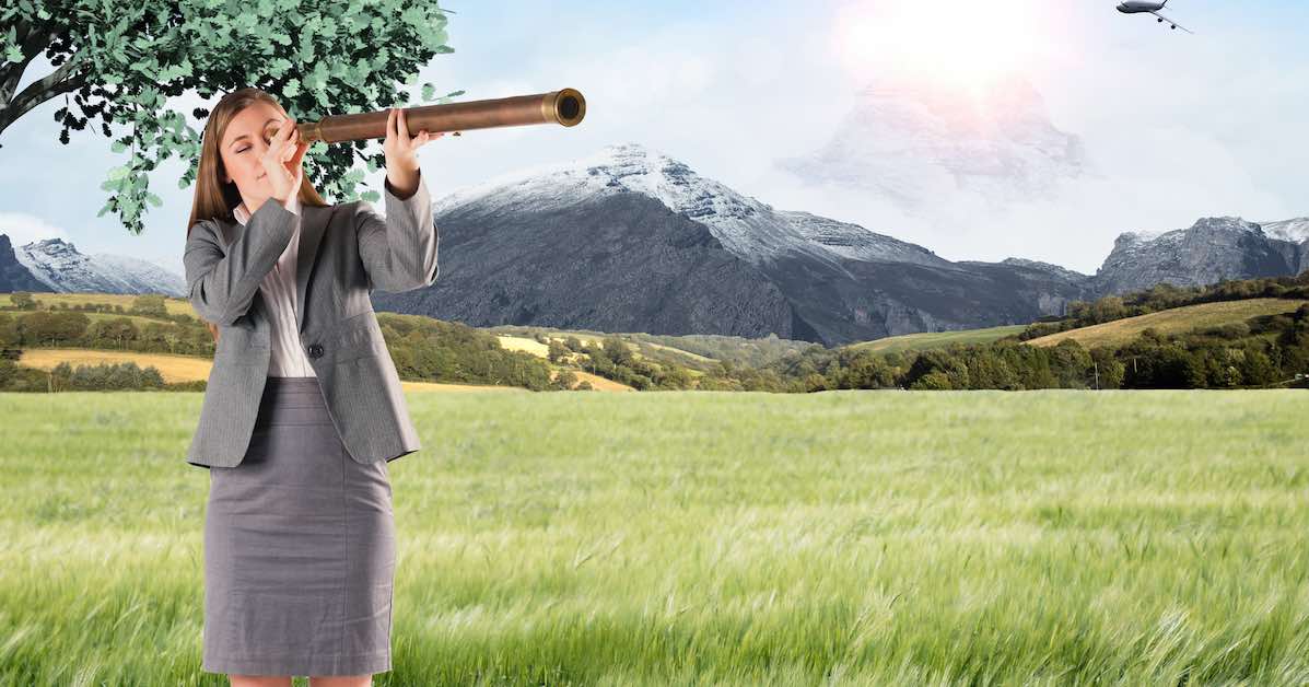 Businesswoman looking through a telescope against scenic backdrop