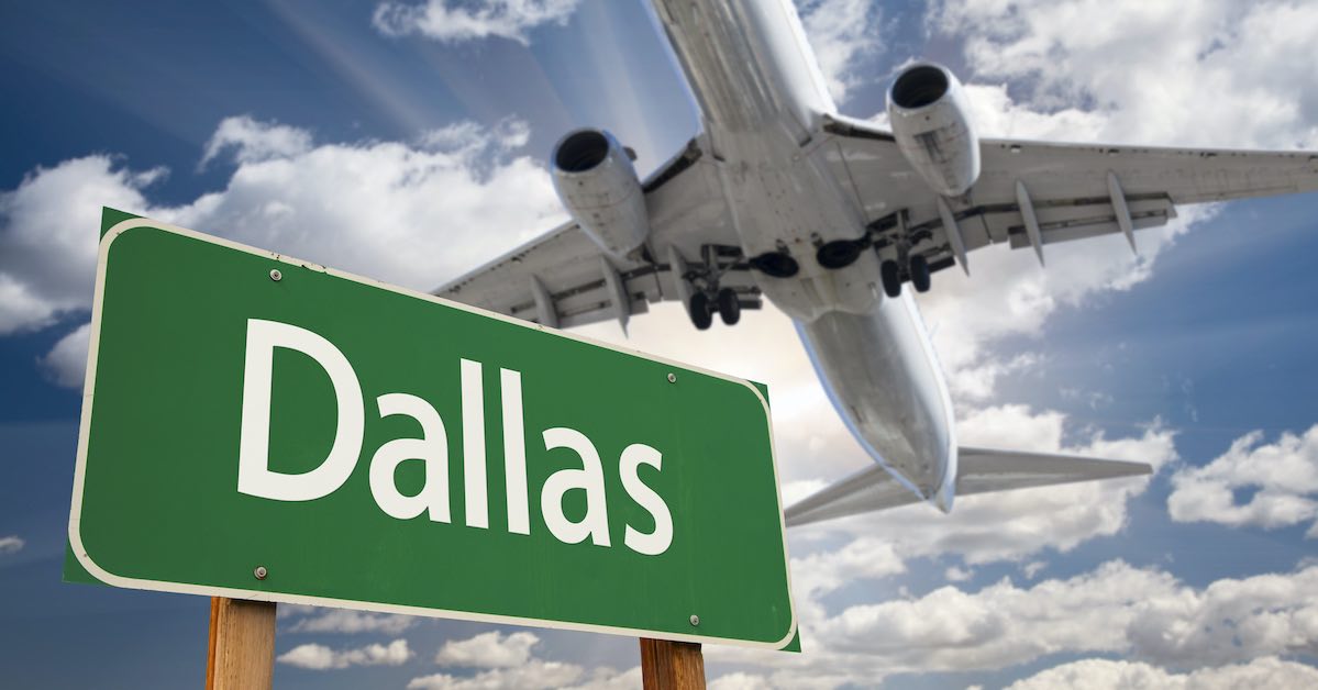 Airplane flying above Dallas green road sign